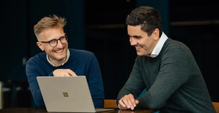 Two men working on a laptop