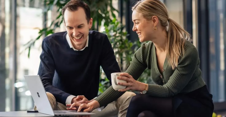 Mann og dame som jobber sammen på en laptop