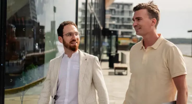 Two businessmen walking and discussing strategies for accounts payable automation and digital invoice management by the waterfront